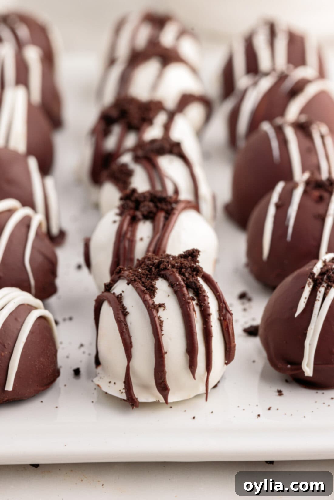 No-Bake Oreo Delights 3 Oreo Truffles perfectly lined on a tray with parchment paper, awaiting decoration.