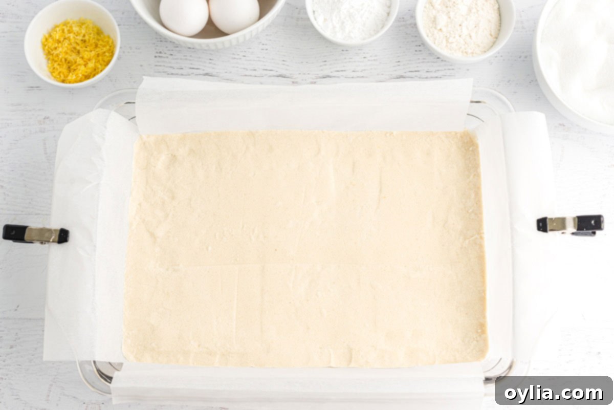 Shortbread crust mixture evenly patted into a baking pan after pre-baking.
