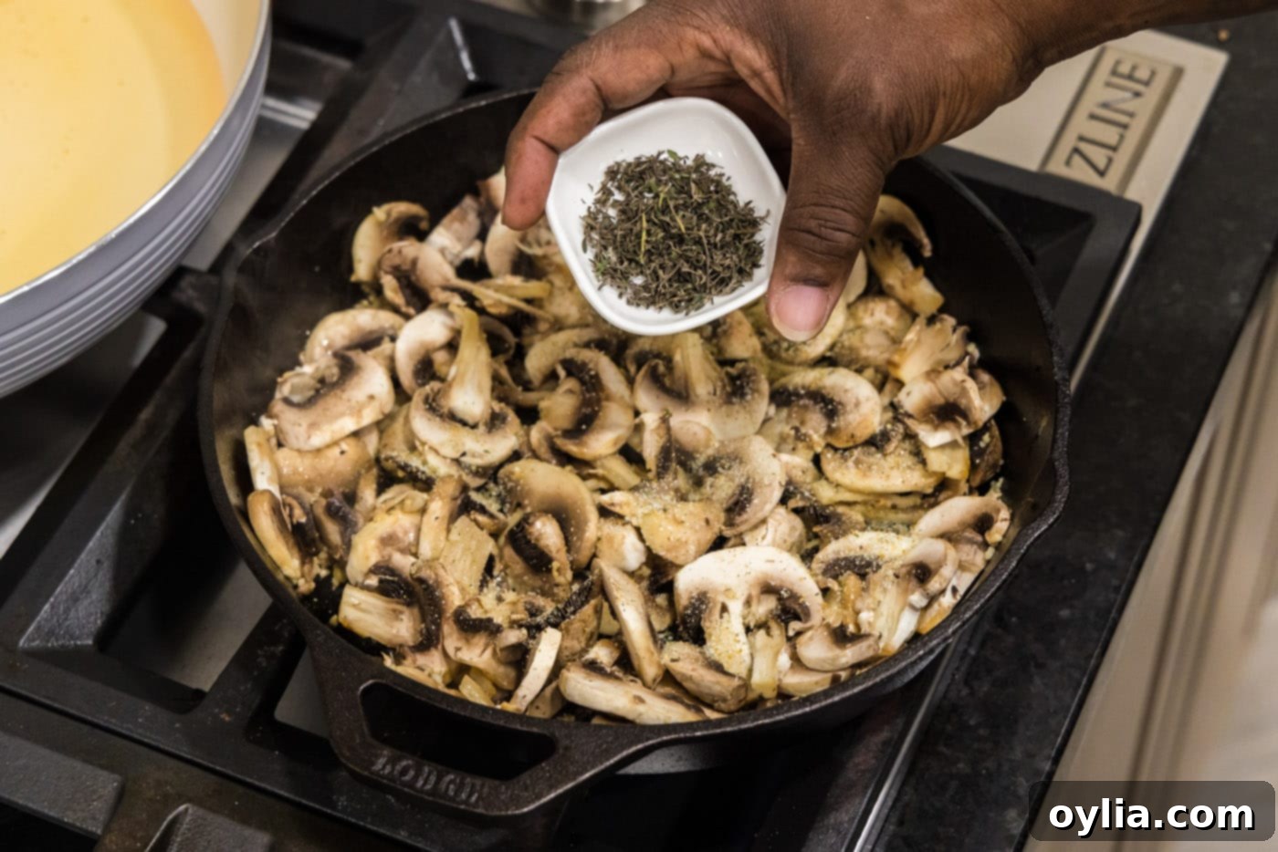adding thyme leaves to skillet with mushrooms