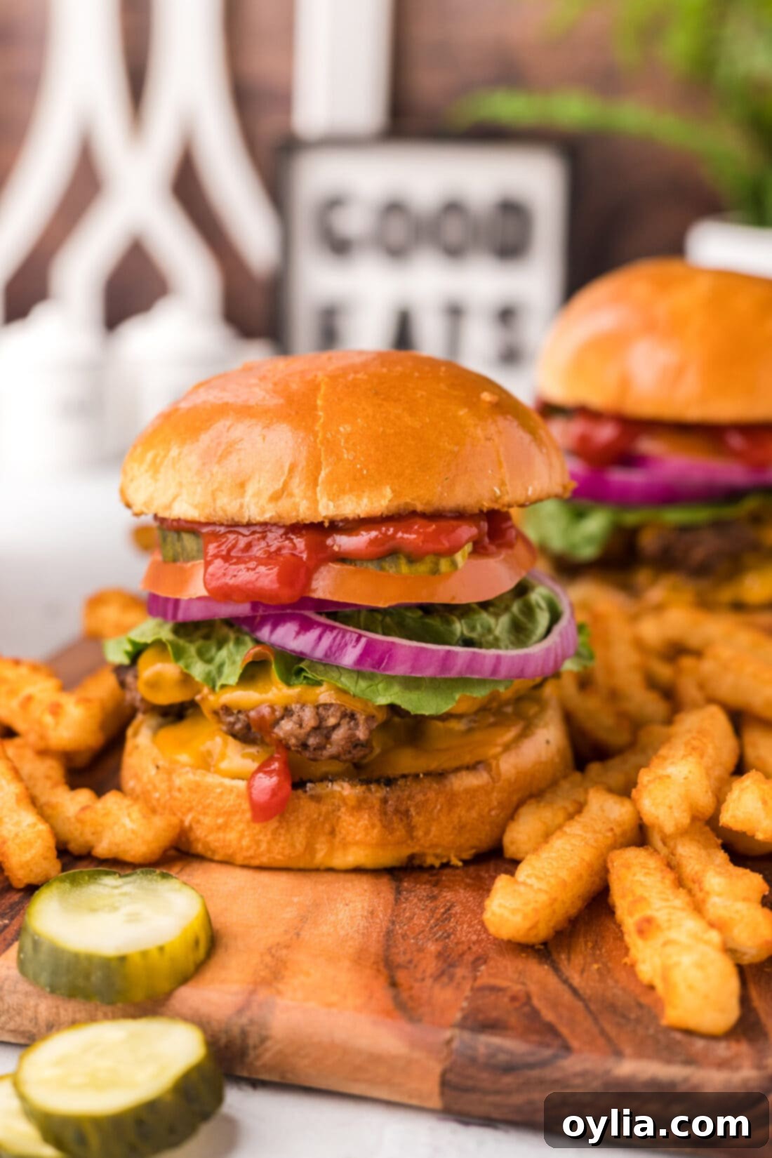 Smash Burger on a platter with pickles and french fries on the side