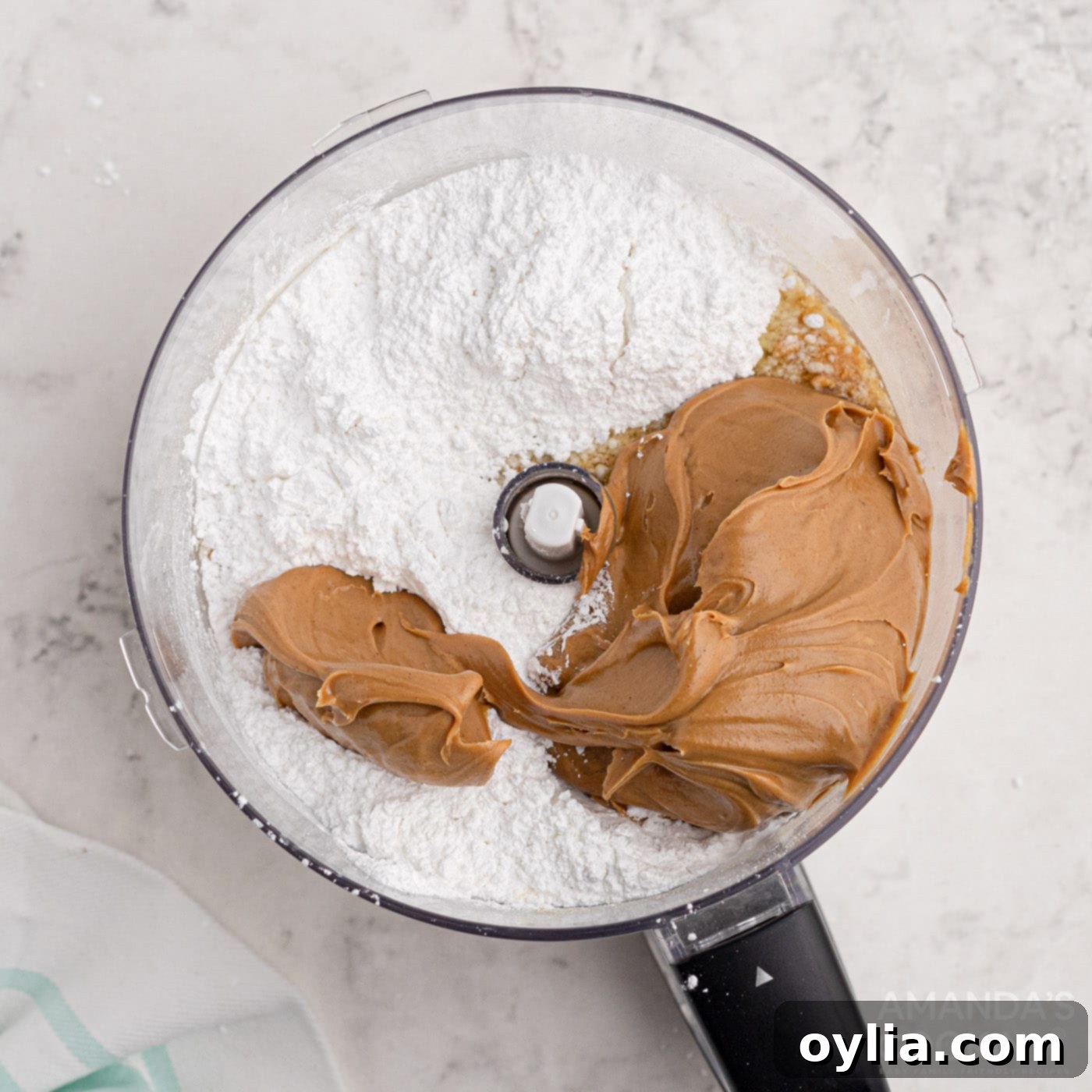 Peanut butter bar base ingredients in a food processor, being combined into a smooth mixture.