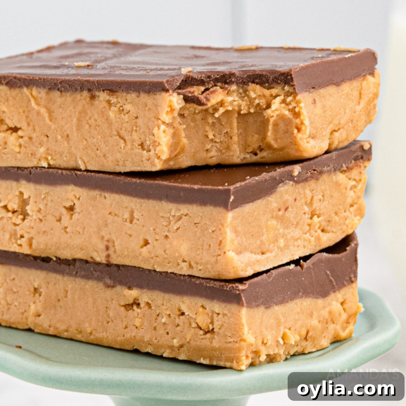 A trio of perfectly cut no-bake chocolate peanut butter bars on a clean white background.