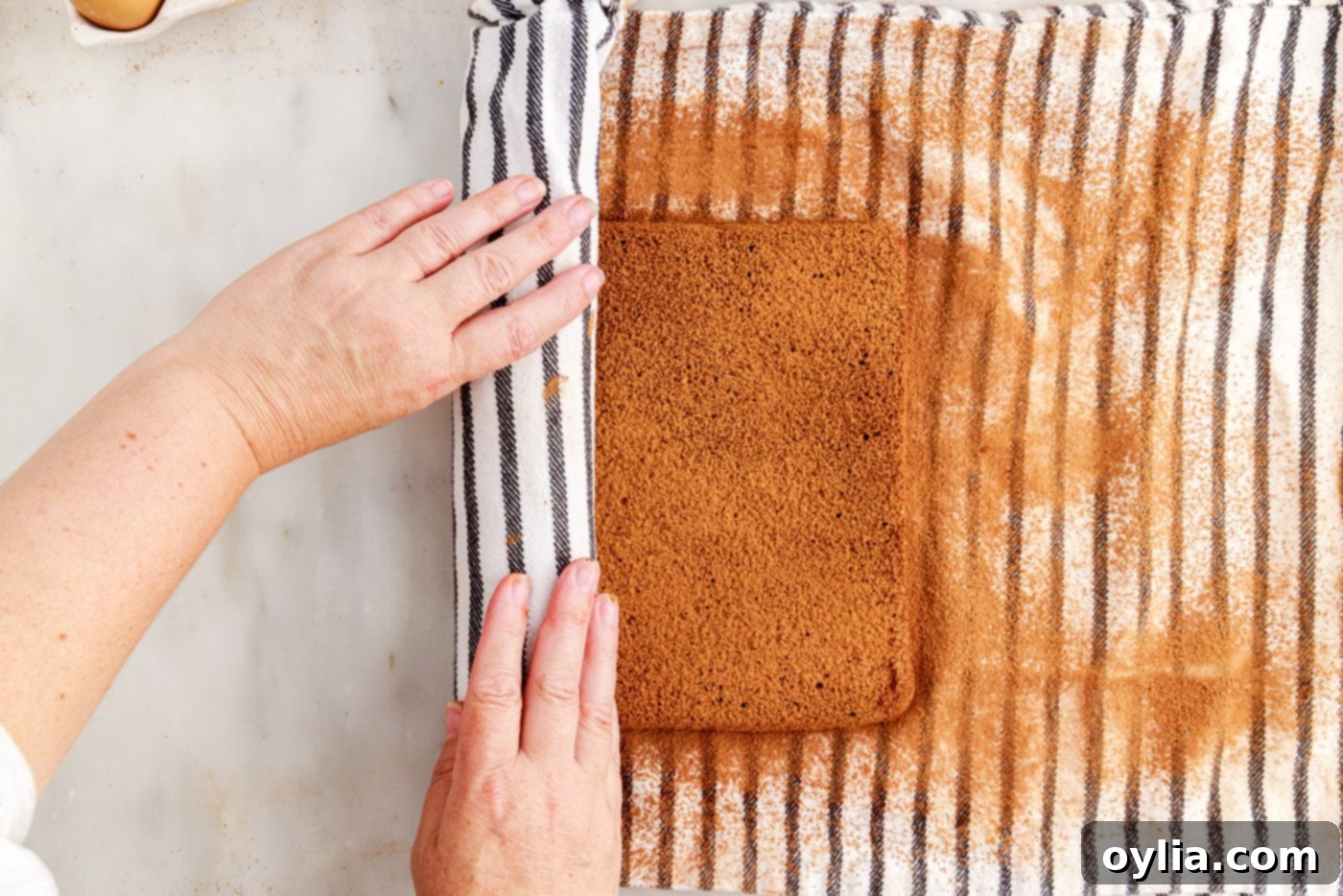 rolling swiss roll cake with a tea towel inside to set its shape