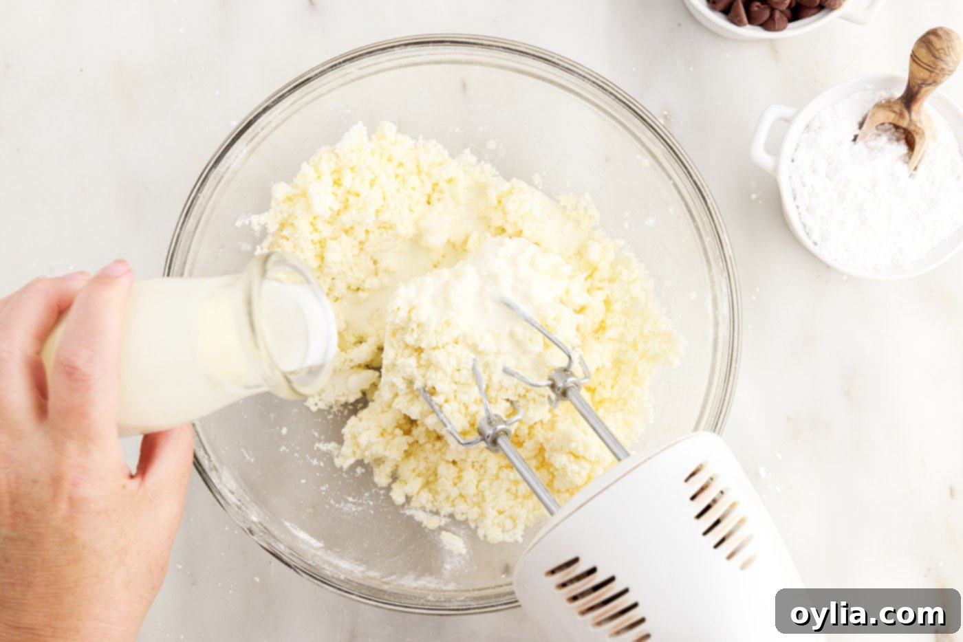 adding heavy cream to the powdered sugar and butter mixture for buttercream