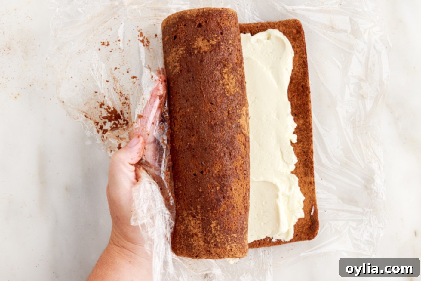 rolling swiss log cake with buttercream filling tightly