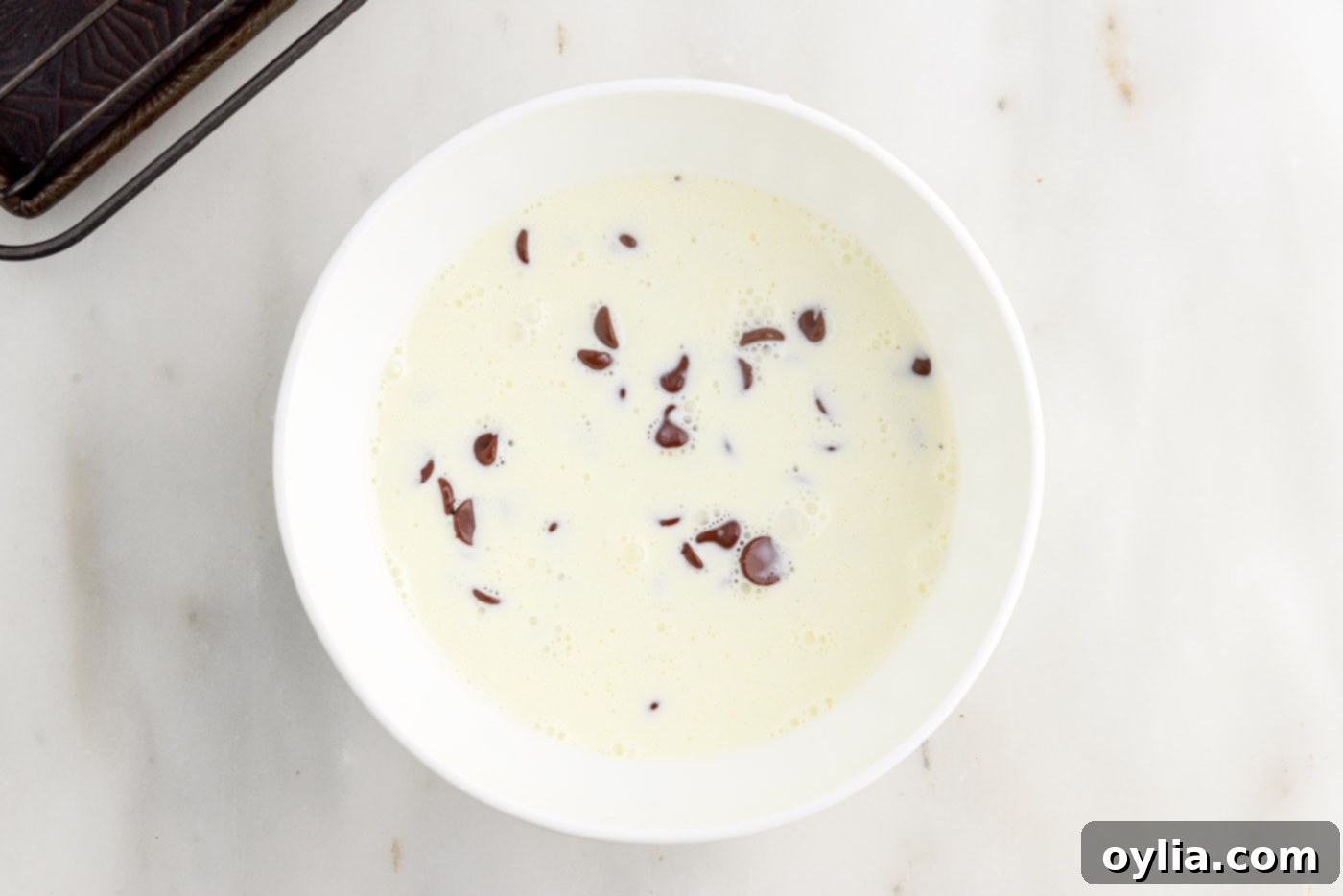 heavy cream and chocolate chips in a bowl, ready to be whisked into ganache