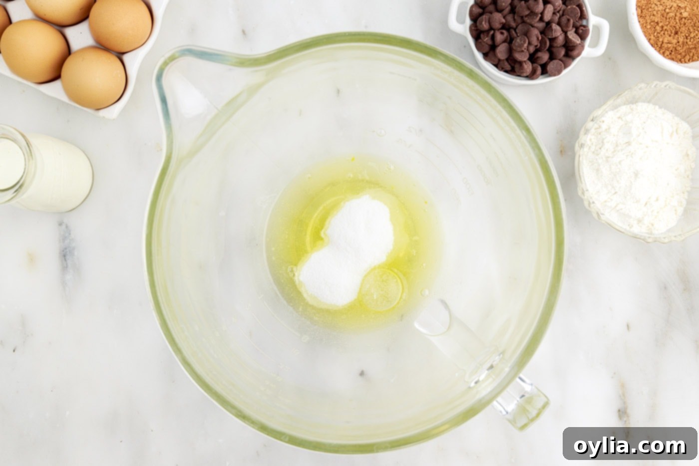 egg whites and sugar in a mixing bowl being whipped by a stand mixer