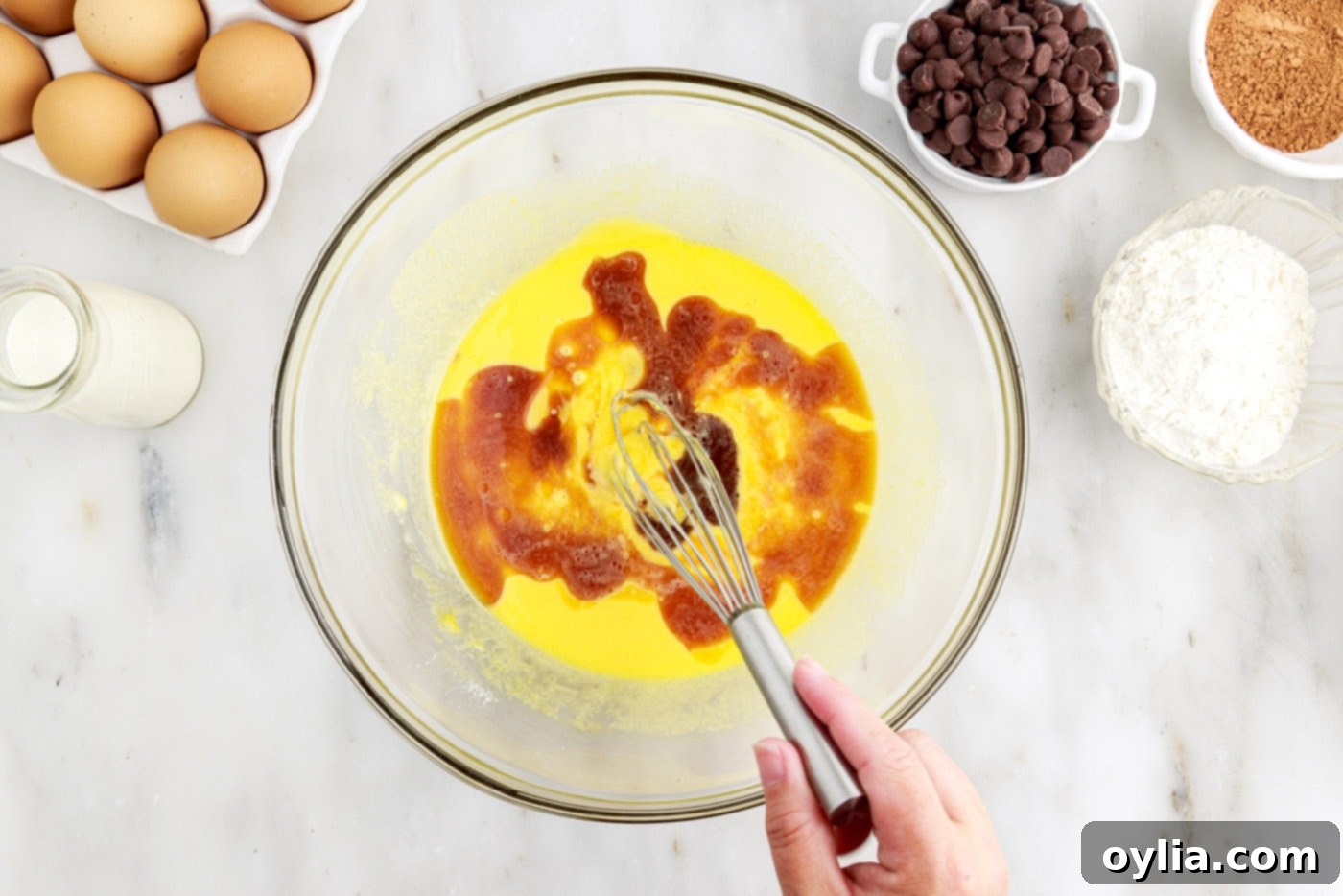 whisking vanilla extract, egg yolks, and vegetable oil in a bowl