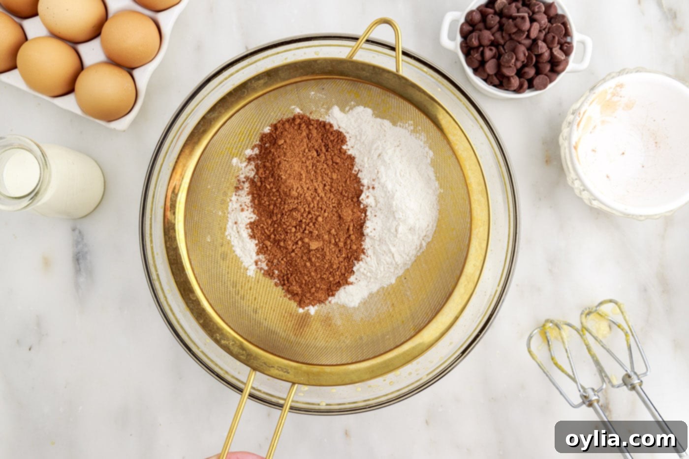 sifting cocoa powder and cake flour into a bowl of wet ingredients