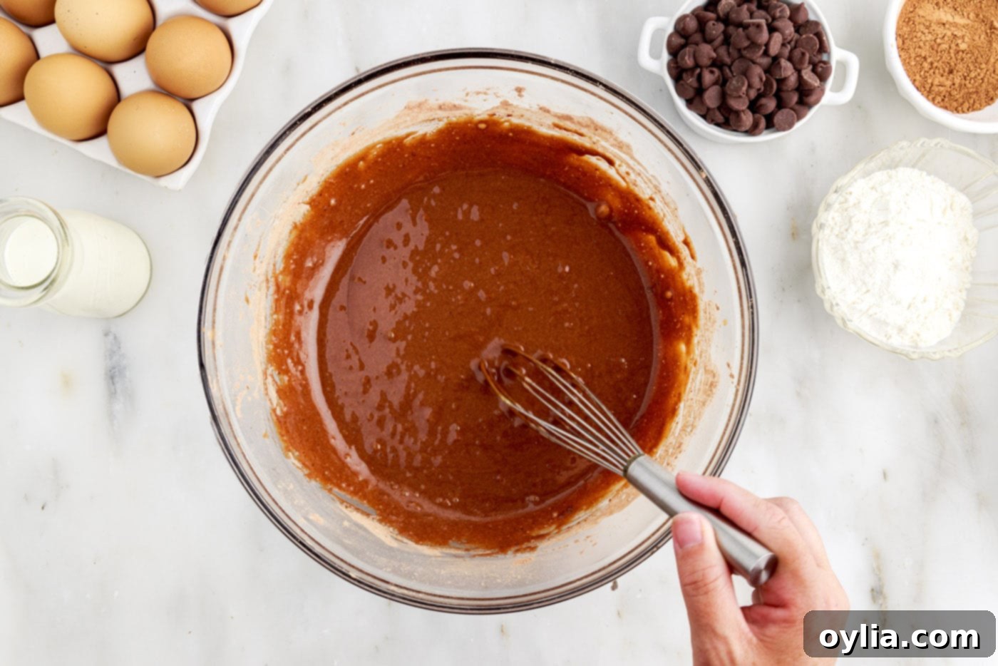 whisking chocolate cake batter in a bowl until smooth