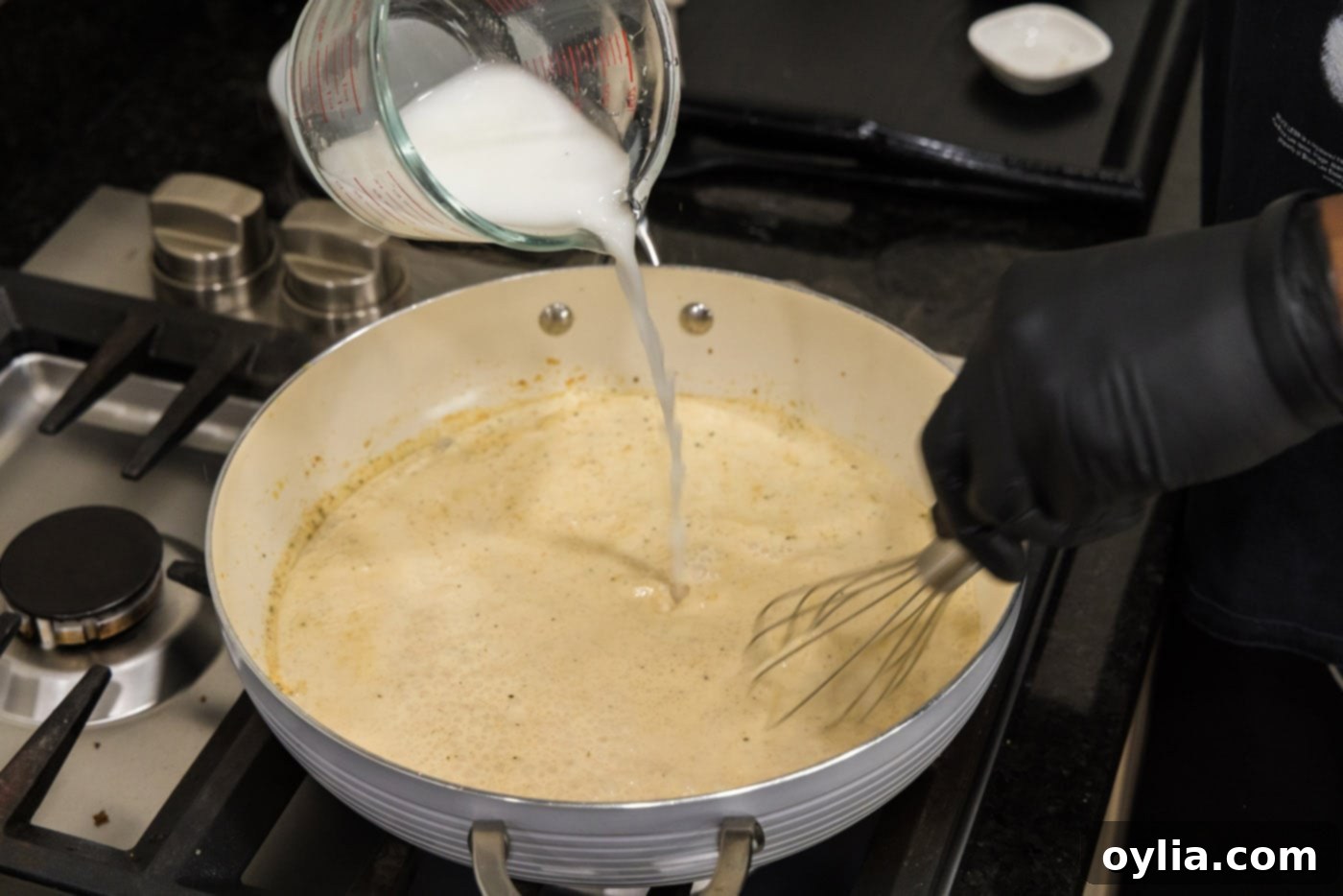 pouring cornstarch slurry in to sauce to thicken