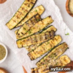 Grilled Zucchini on a wooden platter topped with parmesan cheese, ready to be served.