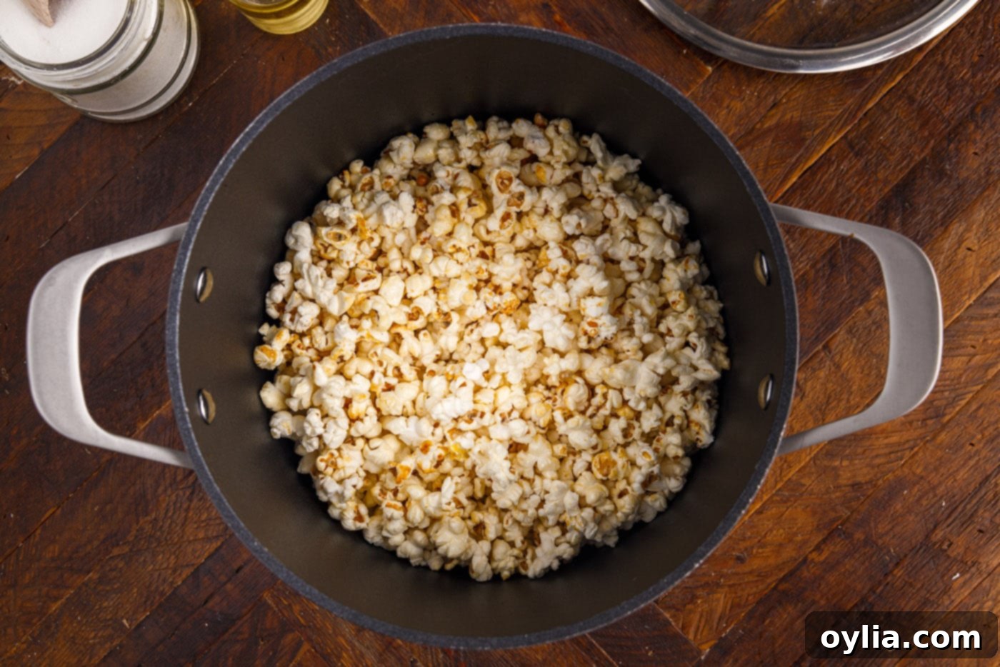 Kettle corn popping on the stovetop inside a pot, indicating the cooking process.