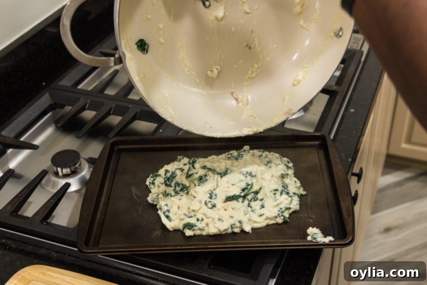 pouring salmon stuffing onto a baking sheet
