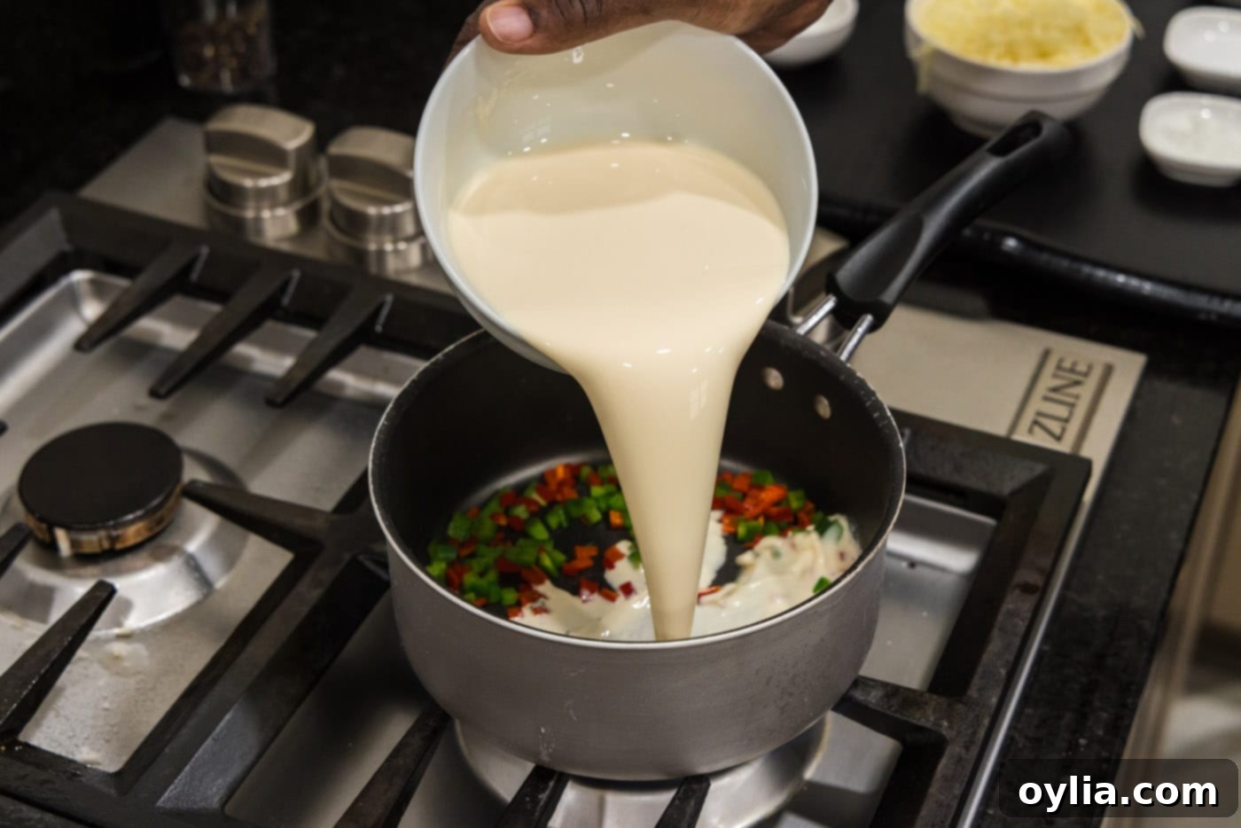 pouring evaporated milk into saucepan with peppers