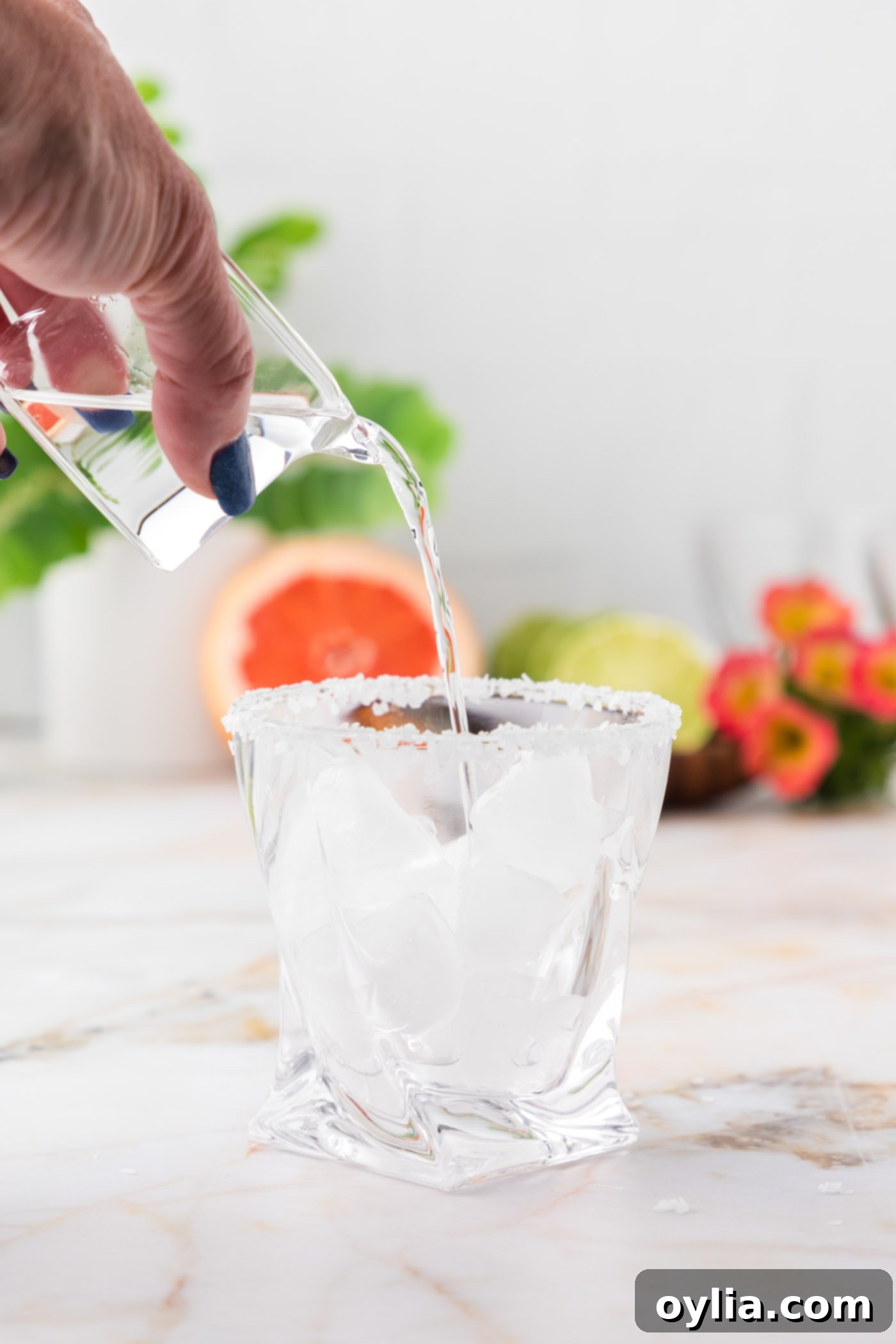 pouring tequila into rock glass