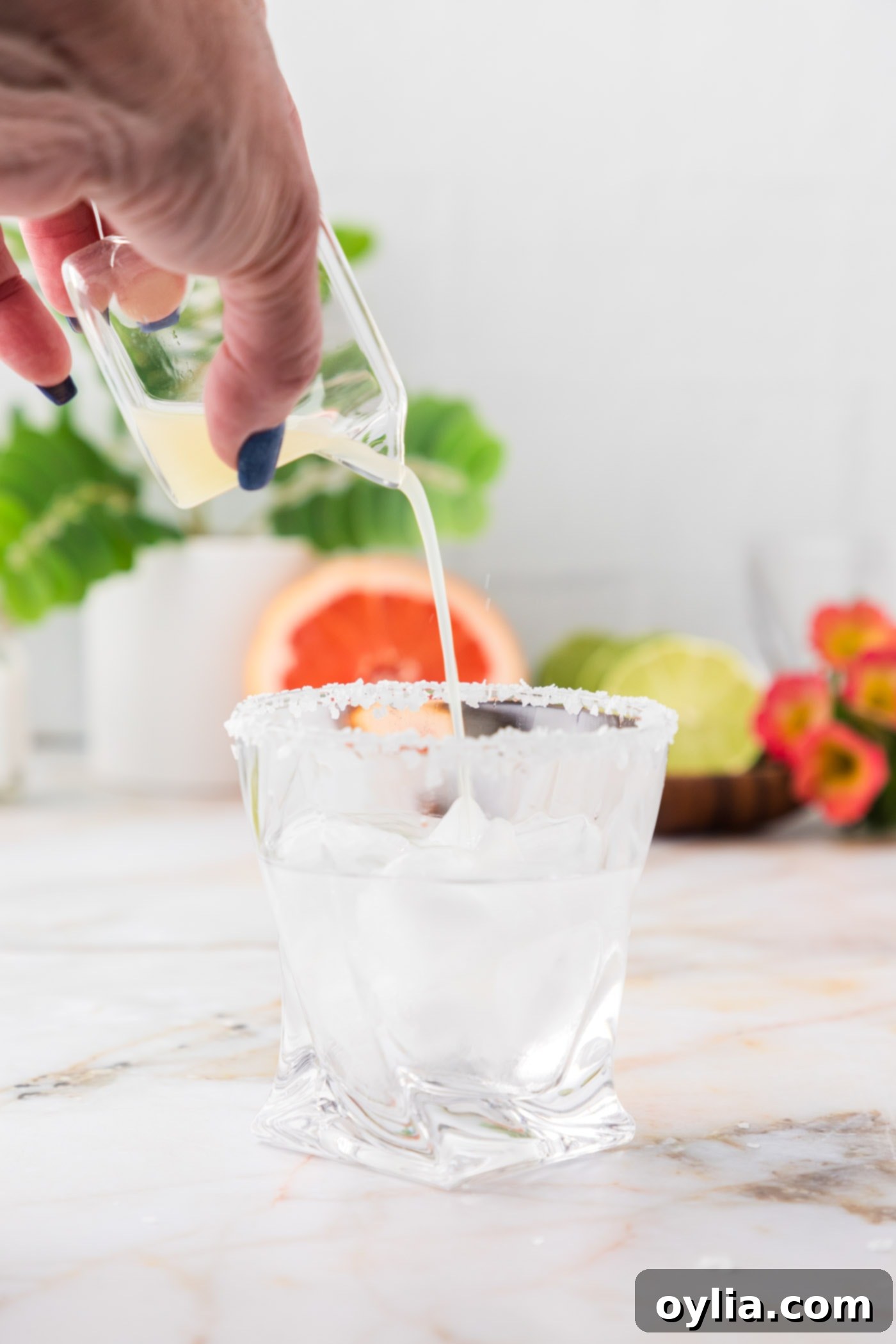 pouring lime juice over blanco tequila