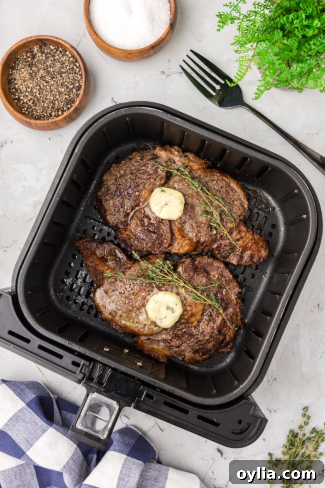 Two perfectly cooked steaks in an Air Fryer basket, showcasing a beautiful brown crust.