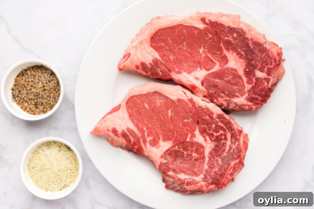 Air Fried Steak Perfection 4 Various ingredients laid out for Air Fryer Steak, including raw steak, Montreal steak seasoning, and garlic salt.