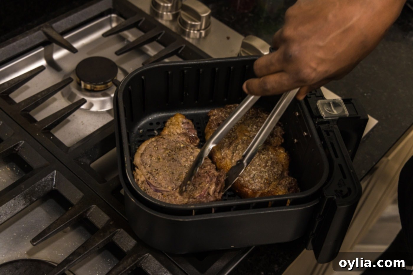 flipping steaks in air fryer basket to cook the other side