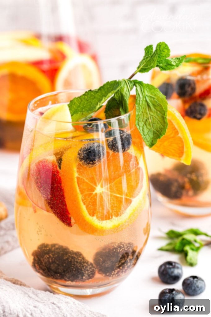 glass of white moscato sangria with fresh fruit and mint garnish