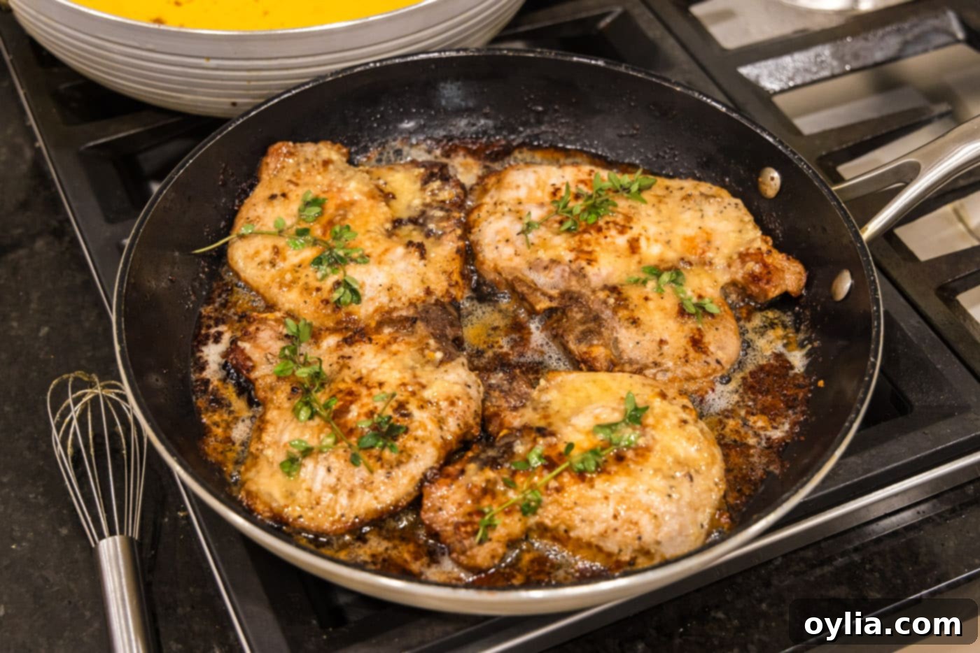 Perfectly cooked garlic butter pork chops resting in the skillet, ready to be removed and served.