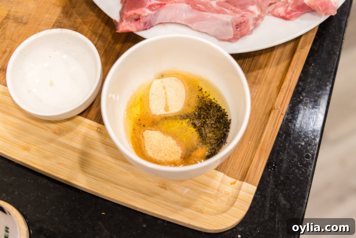 All dry spices combined with olive oil in a bowl, forming a seasoning rub for pork chops.