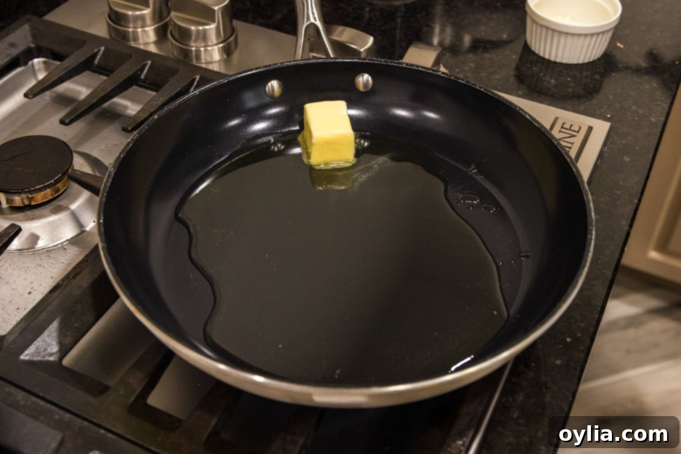 Melted butter and olive oil shimmering in a hot skillet, creating the perfect searing base for pork.