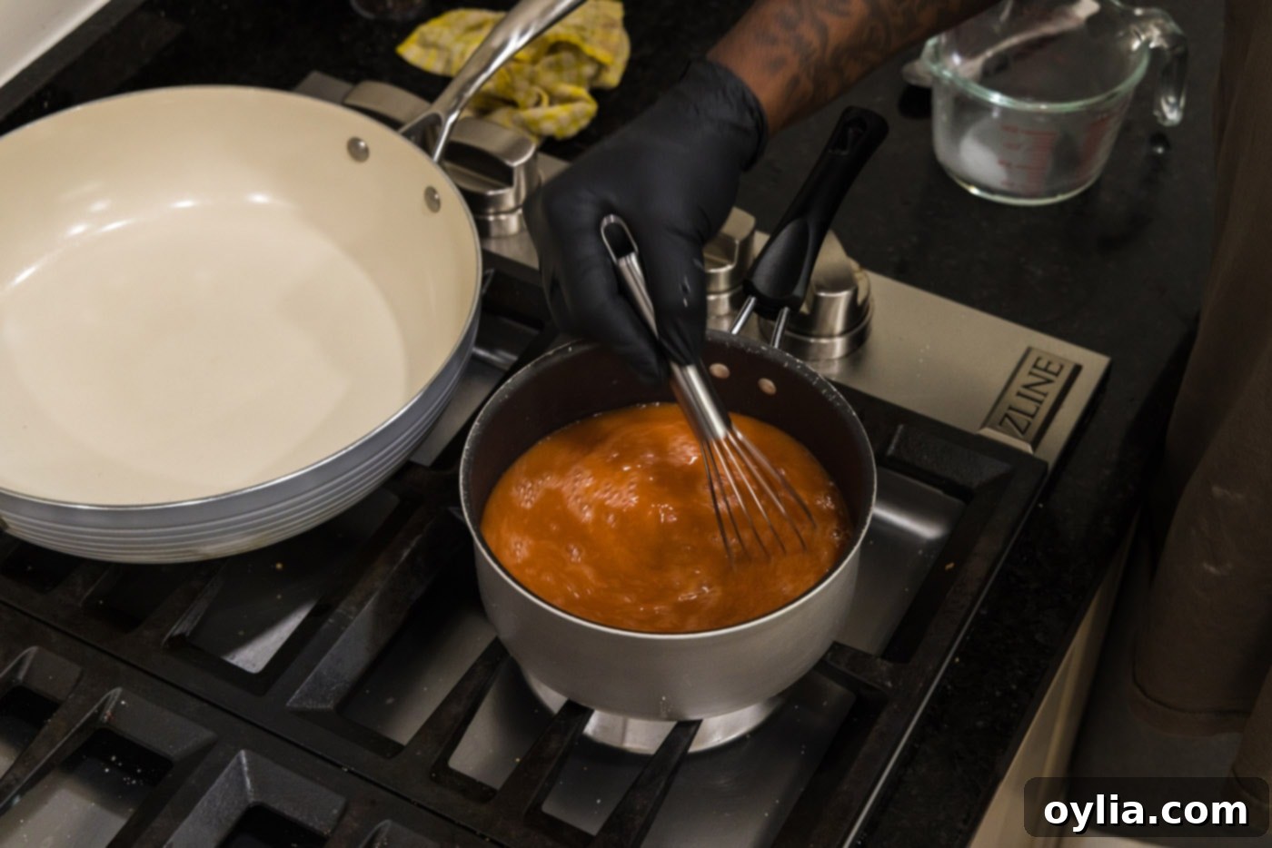 whisking sauce in a pot over heat
