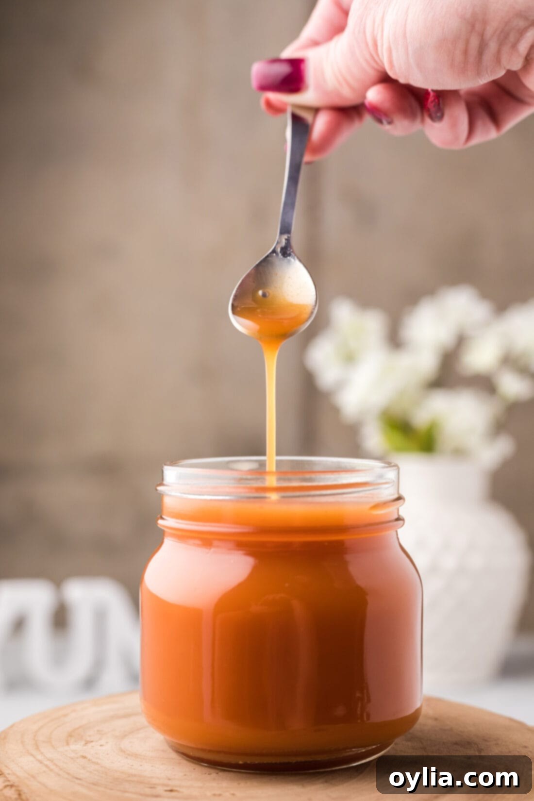 Tangy Sweet Glaze 9 Sweet and Sour Sauce being drizzled off a spoon into a jar