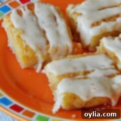 A close up photo of tropical dream dessert bars on an orange plate, perfectly glazed.