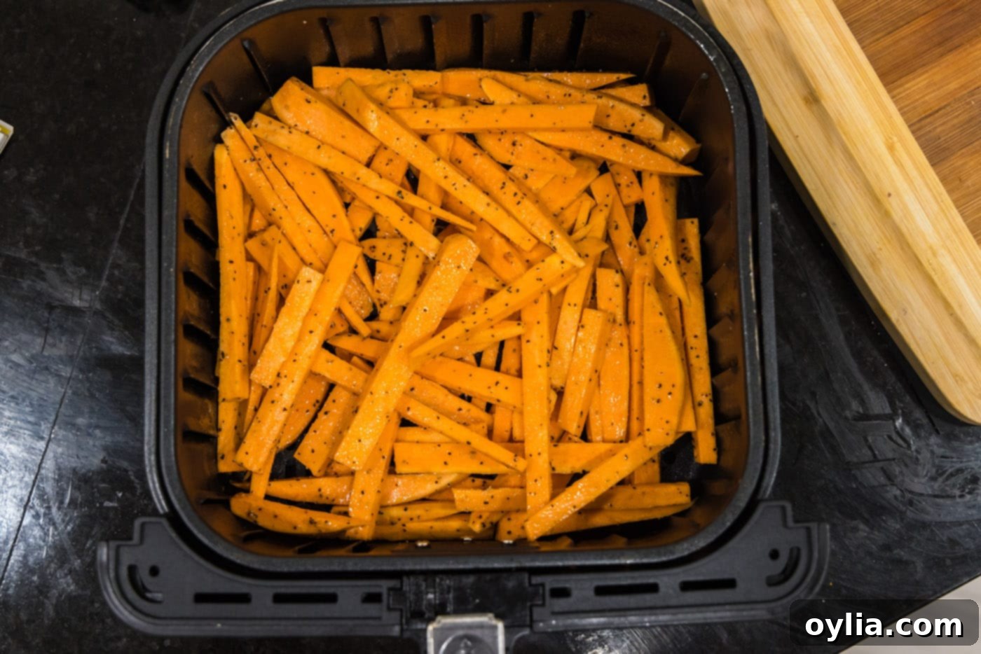 sweet potato fries arranged in a single layer in an air fryer basket