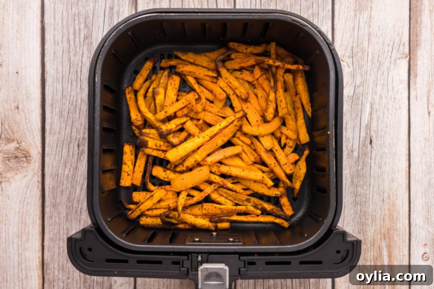 finished air fryer sweet potato fries in a basket, golden and ready to serve