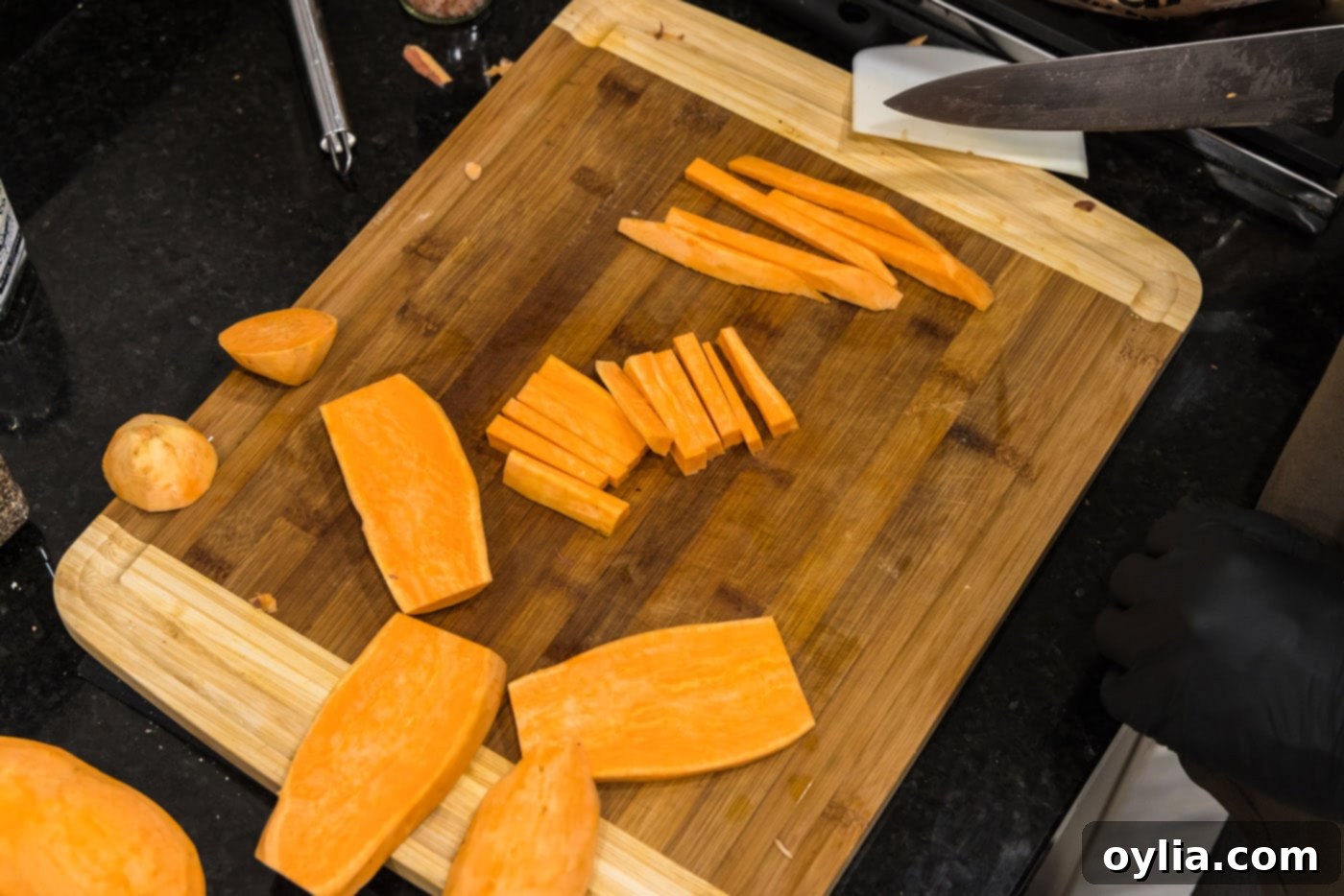 slicing peeled sweet potatoes into thin sticks for air frying