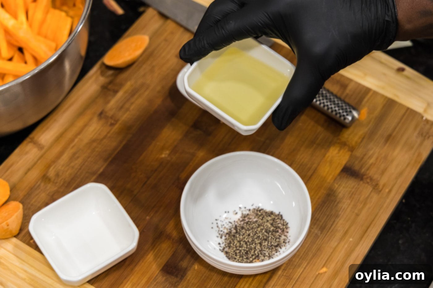 adding olive oil to salt and pepper in a small bowl