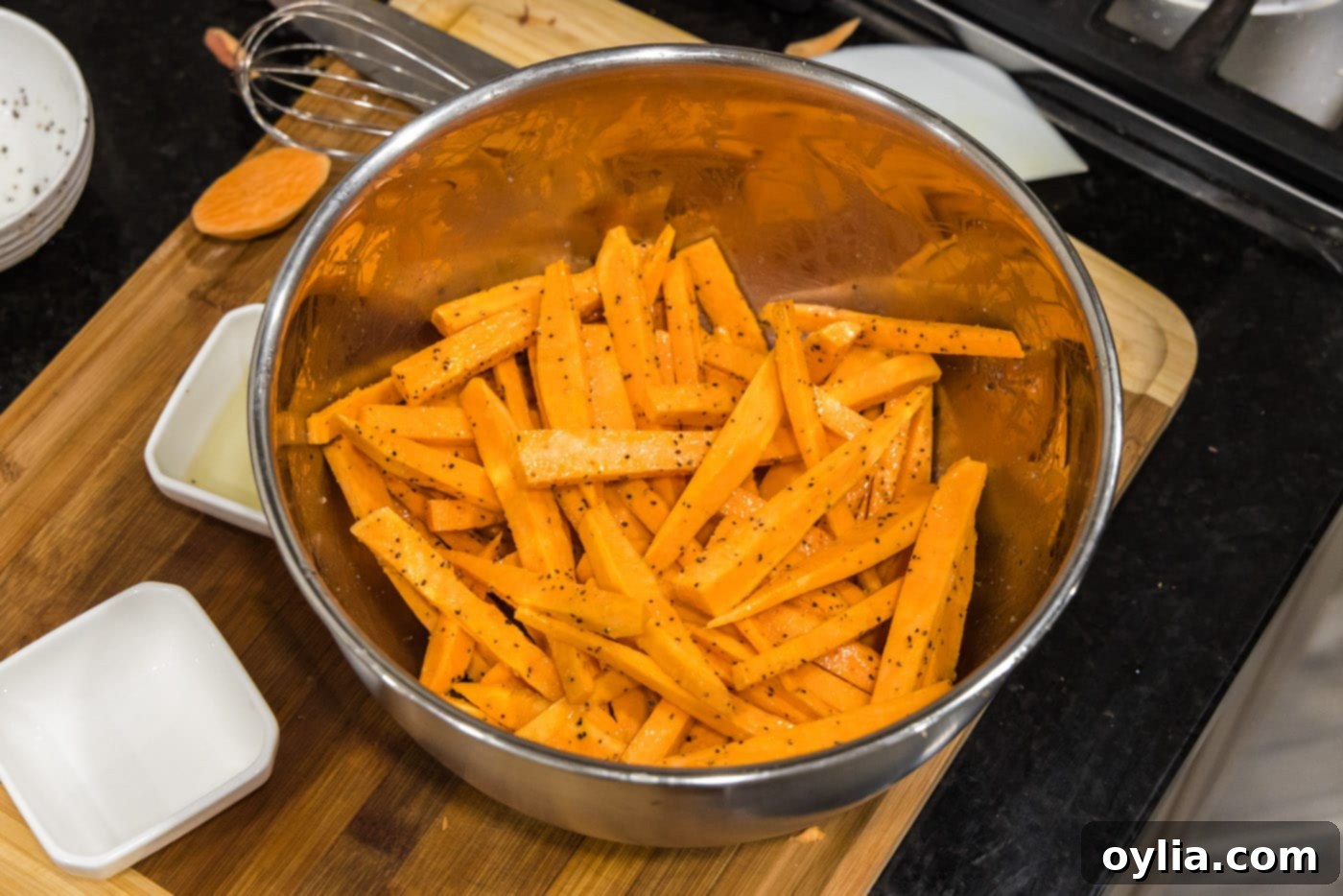 sweet potato fries thoroughly tossed in oil and seasonings in a bowl