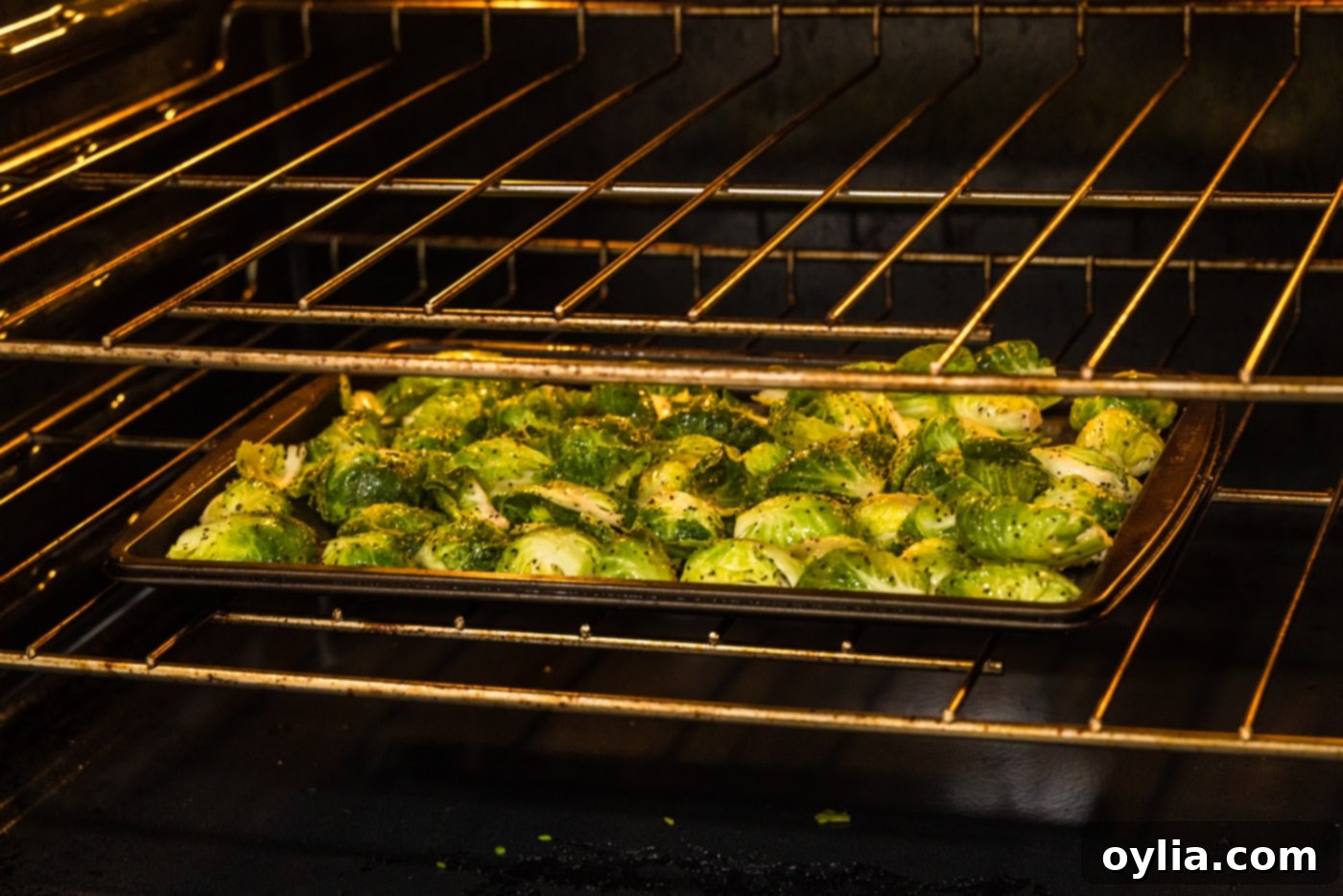 brussels sprouts roasting on a baking sheet inside a hot oven