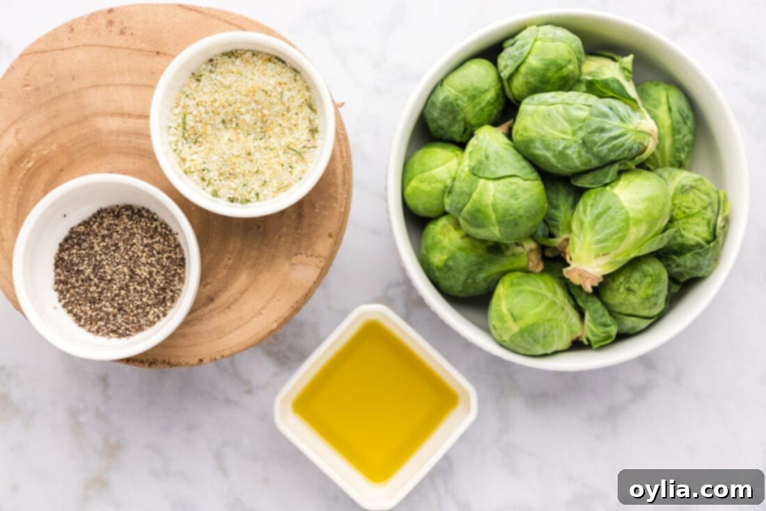 Crispy Roasted Brussels Sprouts 3 Ingredients for Roasted Brussel Sprouts: Fresh sprouts, olive oil, garlic salt, black pepper laid out on a wooden surface