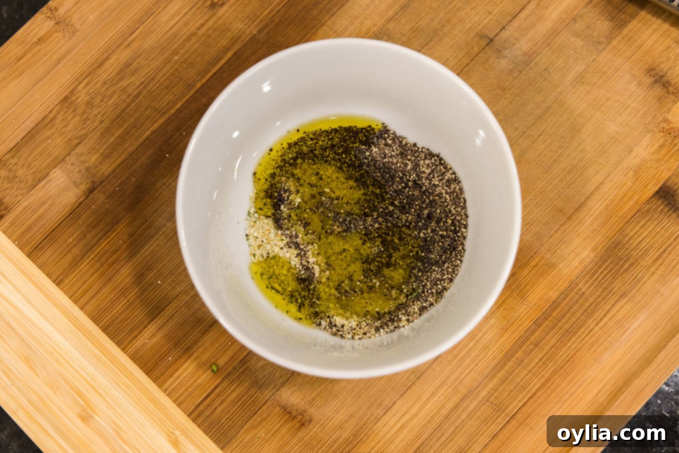 olive oil, garlic salt, and pepper in a bowl, perfectly mixed and ready for the sprouts