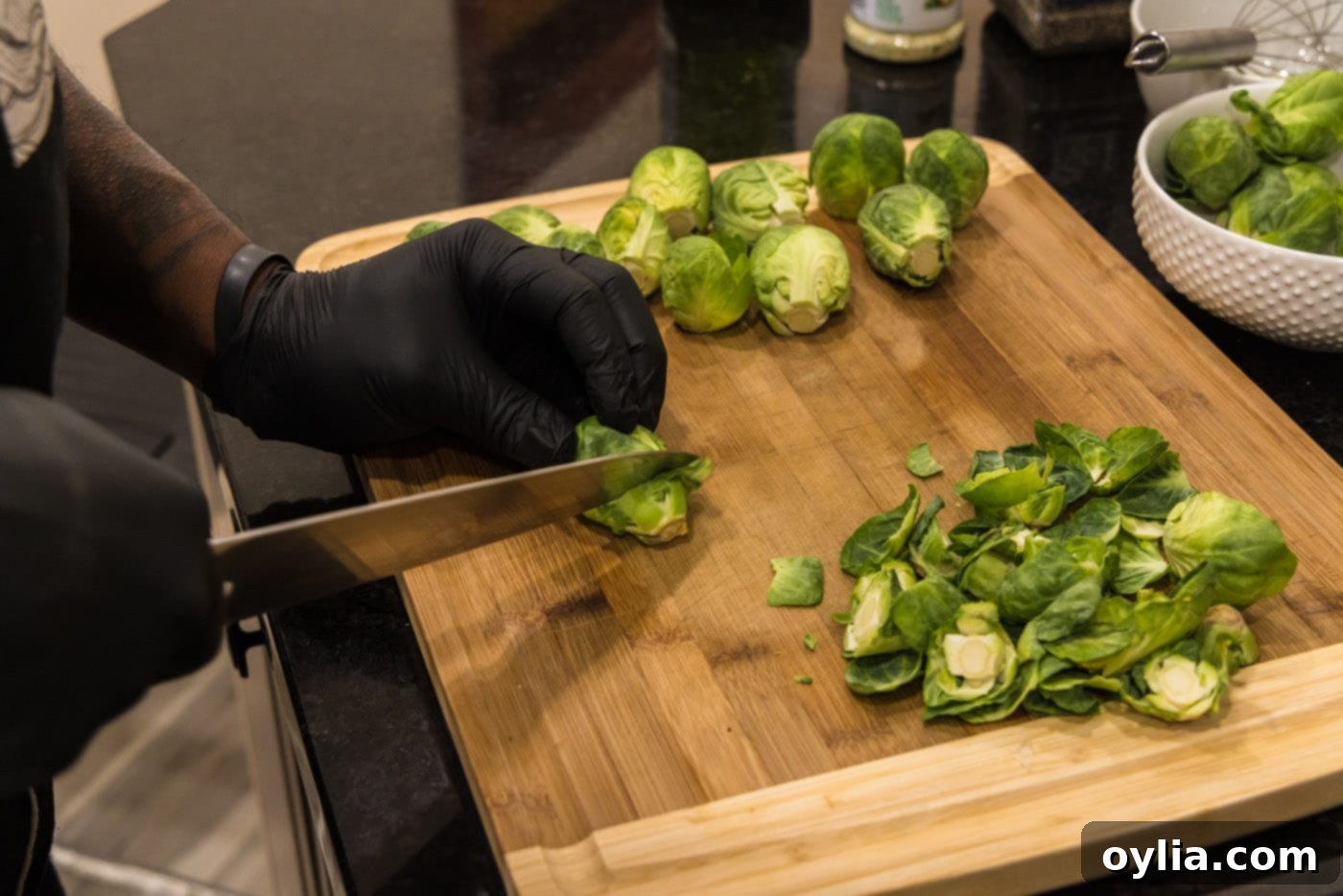 a hand trimming the woody end off a brussels sprout