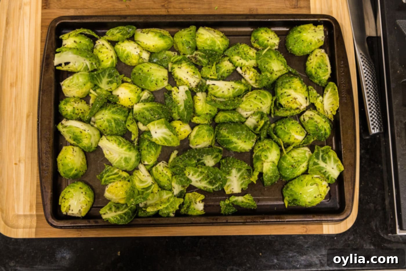 brussels sprouts arranged cut side down on a baking sheet, ready for roasting