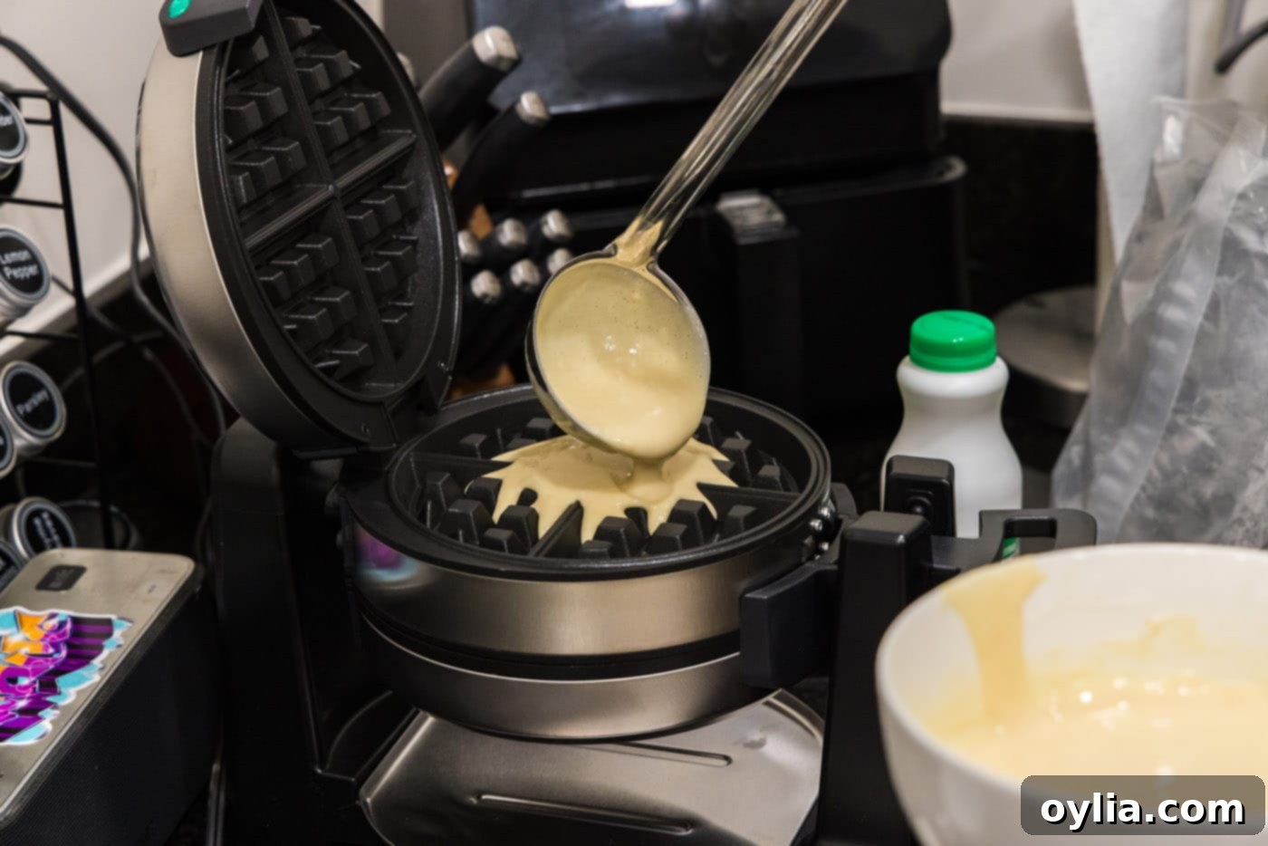 ladle pouring waffle batter into waffle iron