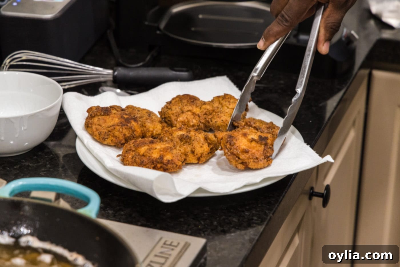 crispy fried boneless chicken highs on a paper towel lined plate