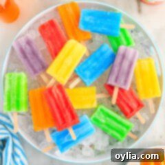 An assortment of colorful Jello Popsicles, perfectly frozen, resting over a bed of ice in a bowl, highlighting their refreshing appeal.