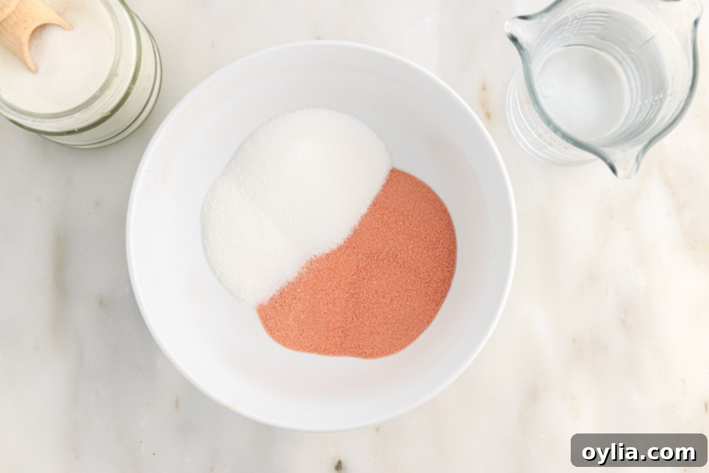 Jello powder and granulated sugar mixed in a medium bowl, showing the dry ingredients before water is added.