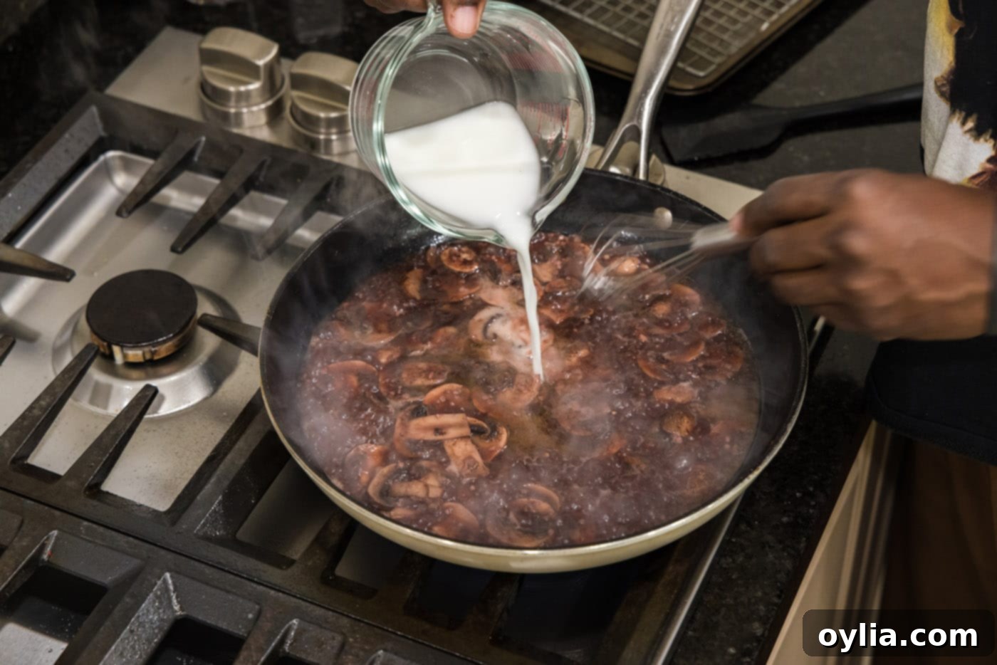 Pouring a cornstarch slurry into the mushroom Marsala sauce to thicken it.