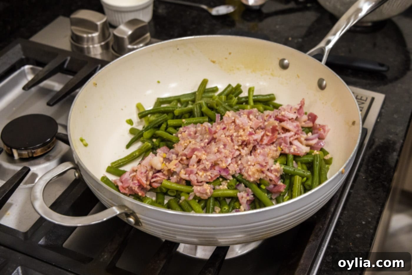 Adding cooked shallots, bacon, and garlic back into the southern green beans