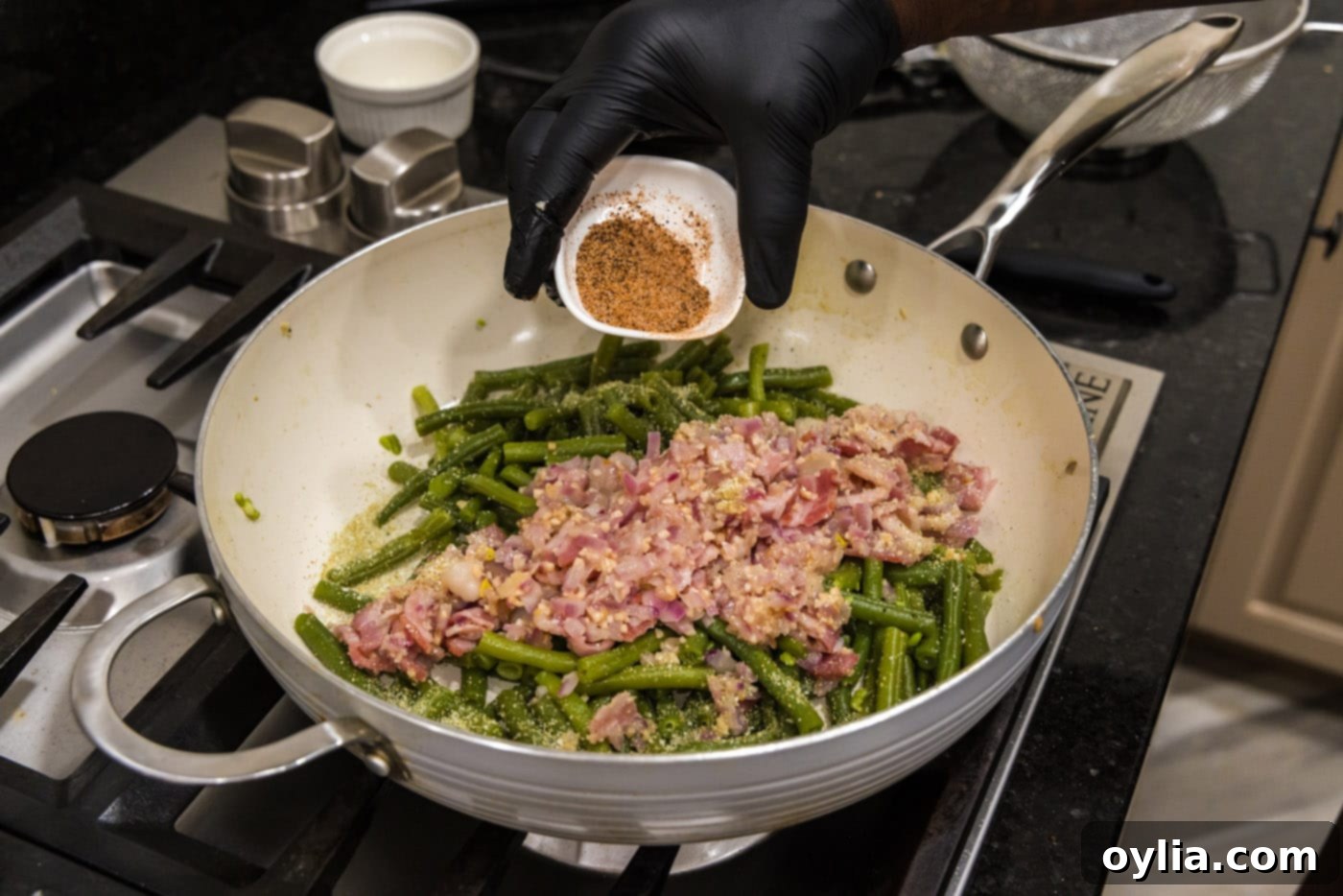 Adding more Cajun seasoning to the finished southern green beans