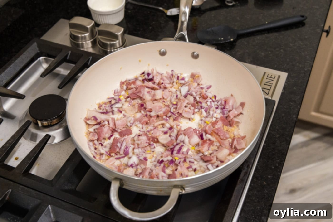 Skillet showing shallots, garlic, and bacon cooking together
