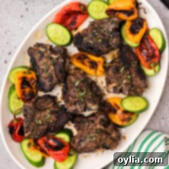Succulent Grilled Lamb Loin Chops 14 Grilled Lamb Loin Chops on a platter with roasted peppers and sliced cucumbers